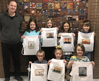 elementary students holding up their bags