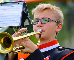 male student playing his trumpet
