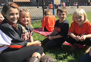 group of students wearing Port Allegany gear sitting in the grass