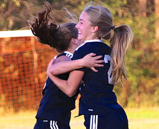 two female soccer players hugging