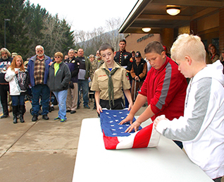 three boys folding the United States flag