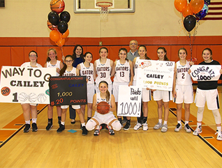 girls basketball team holding signs