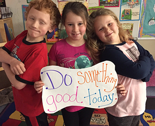 three students holding a sign that says Do something Good Today.